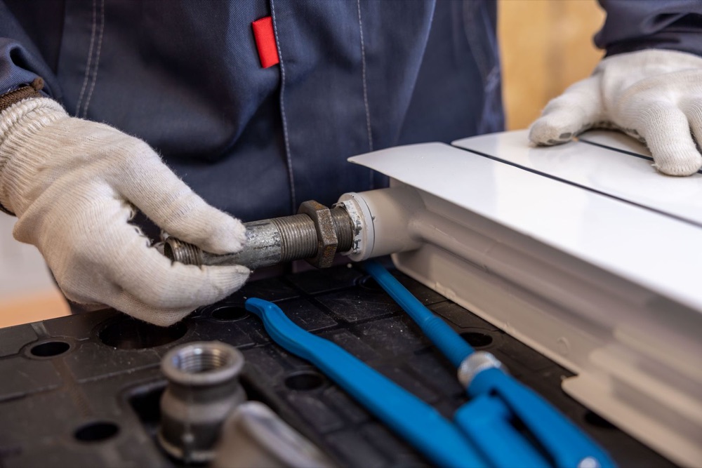 Engineer working on heating pipework during a repair
